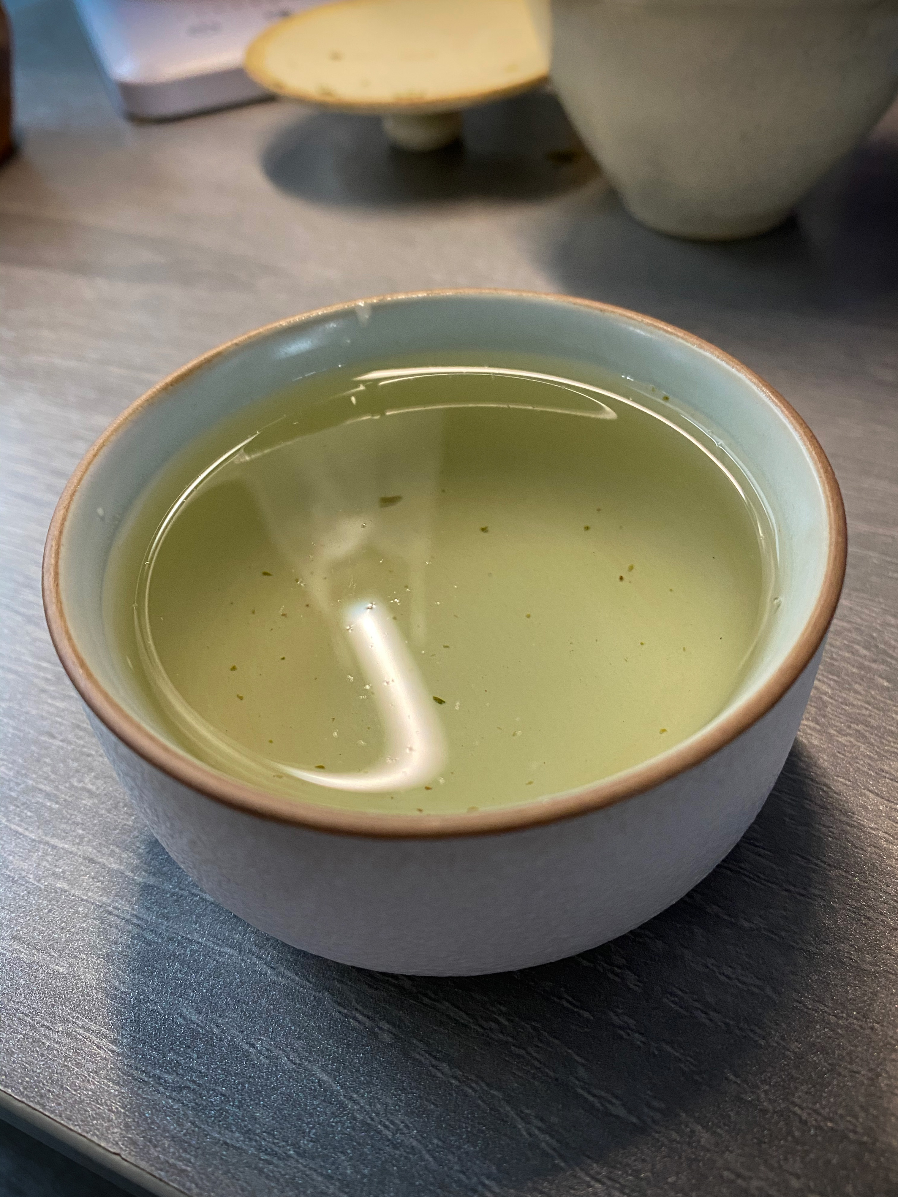 Liquor in wide cup with a pale yellow-green tinge.